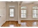 Bright foyer with hardwood floors, transom window door, and large arched windows at 375 Causeway Ct, Suwanee, GA 30024