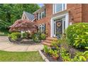Inviting front porch showcasing colorful plantings, beautiful landscaping, and a stately brick facade at 420 Windswept Ct, Roswell, GA 30075