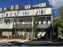 A view of modern townhomes featuring gray siding, dark trim, and inviting covered front porches at 4200 Legacy Ln # 22, Acworth, GA 30101