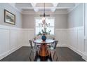 Elegant dining room with coffered ceiling, wainscoting, and modern chandelier at 2370 Bradwardine Ct, Cumming, GA 30041