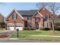 Well-maintained two-story brick home with a manicured front lawn and a two-car garage at 1107 Carroll Ct, Norcross, GA 30071