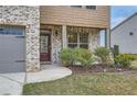 Inviting entryway with a dark wood door, brick facade, and landscaped garden bed and a 'Welcome' sign at 1262 Brookstone Cir, Conyers, GA 30012