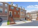 Brick townhome with a one-car garage, a front door staircase, and a well-maintained lawn at 2690 Derby Ne Walk # 53, Atlanta, GA 30319