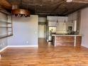 Open-concept living room with hardwood floors leading to a kitchen area with modern appliances at 3235 Roswell Ne Rd # 521, Atlanta, GA 30305