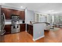 Modern kitchen with stainless steel appliances, rich wood cabinets, and an open layout to the living space at 375 Highland Ne Ave # 913, Atlanta, GA 30312