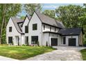 Two story home with gray roof and black trim and a three car garage at 4091 Oak Forest Ne Dr, Brookhaven, GA 30319