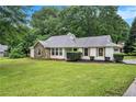 Well-maintained single-story home with lush lawn, attractive stone accents, and manicured shrubs at 110 Peach Pointe Dr, Mcdonough, GA 30253