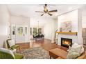 Open-concept living area with fireplace, hardwood floors, and views into the dining area at 110 Peach Pointe Dr, Mcdonough, GA 30253