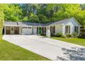 Inviting single-story home with white brick, dark shutters, attached garage, and a long driveway at 3176 Gablewood Ct, Decatur, GA 30033