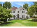 Charming two-story home with a lush green lawn and a beautiful entrance under a colorful sunset sky at 3845 Winters Hill Dr, Atlanta, GA 30360