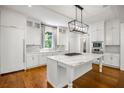 Beautiful kitchen with white cabinetry, marble countertops, stainless steel appliances, and modern island at 9179 Selborne Ln, Chattahoochee Hills, GA 30268