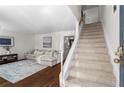 Bright living room with hardwood floors, a cozy sectional, and a staircase leading to the upper level at 1028 Riverbend Club Se Dr, Atlanta, GA 30339