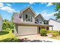 View of the exterior featuring two story facade, gray siding, garage door, and a well-manicured yard at 4065 Waters End Ln, Snellville, GA 30039