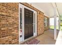 Covered porch with a brick facade leading to a black front door with sidelights and a 'welcome friends' mat at 4065 Waters End Ln, Snellville, GA 30039