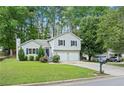Traditional two-story home with a manicured lawn, mature trees, and a two-car garage at 5590 Princeton Oaks Dr, Sugar Hill, GA 30518