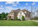 Two-story home with brick and siding exterior, green lawn and manicured landscaping at 3915 Northridge Dr, Cumming, GA 30040