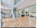 Bright open-concept living space with hardwood floors, a staircase, and a glass railing at 7504 Rivertown Rd, Fairburn, GA 30213
