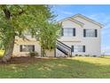 Charming two-story home with a large front yard and stairs leading to the entrance at 7760 Poppy Dr, Winston, GA 30187