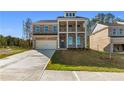 Two story brick home featuring a two-car garage, second story porch, and manicured front lawn at 101 Belvedere Rd, Mcdonough, GA 30253