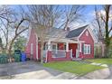 Charming red home features a covered porch, green lawn, and classic architectural details at 1081 Longley Nw Ave, Atlanta, GA 30318