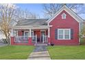 Charming red home features a covered porch, green lawn, and classic architectural details at 1081 Longley Nw Ave, Atlanta, GA 30318