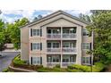 Multi-story condo exterior featuring private balconies and manicured landscaping, framed by green trees at 1250 Parkwood Se Cir # 1203, Atlanta, GA 30339