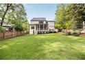 Expansive backyard featuring a lush lawn, screened porch, back deck, and mature trees offering privacy at 304 Meadowbrook Ne Dr, Atlanta, GA 30342