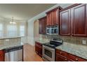 View of kitchen with stainless steel appliances, granite countertops and dark wood cabinets at 3912 Margaux Dr, Atlanta, GA 30349
