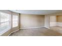 Bright living room featuring large windows and neutral carpeting, creating a warm and inviting atmosphere at 5246 Salem Springs Pl, Lithonia, GA 30038
