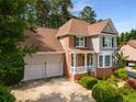 Attractive home with a two-car garage, manicured landscaping, brick accents, and a charming covered porch at 825 Yosemite Dr, Suwanee, GA 30024