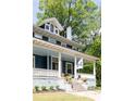 Close up of charming home featuring a welcoming front porch and a beautifully landscaped front yard at 118 Waverly Way, Atlanta, GA 30307