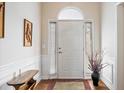 Bright foyer featuring a white front door flanked by sidelights, wainscoting, and hardwood floors at 11865 Brisbane Dr, Alpharetta, GA 30009