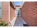 Close-up of a brick house entrance with a gray front door and surrounding trim and greenery at 11865 Brisbane Dr, Alpharetta, GA 30009