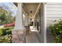 Covered front porch with stone accents, columns, and landscaped surroundings offers a welcoming entrance at 516 Winder Trl, Canton, GA 30114