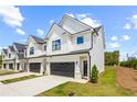 New townhome exterior with white siding, a black garage door, and a well-manicured lawn at 212 Starr Cir, Stockbridge, GA 30281