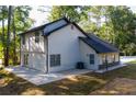 Rear exterior of home with a concrete patio and light siding surrounded by a yard and trees at 3563 Brenda Ct, Douglasville, GA 30135