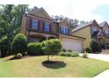 Charming two-story home with a manicured lawn and two car garage at 3877 Lake Sanctuary Way, Atlanta, GA 30349