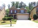Charming two-story home with a manicured lawn and two car garage at 3877 Lake Sanctuary Way, Atlanta, GA 30349