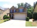 Charming two-story home with a manicured lawn and two car garage at 3877 Lake Sanctuary Way, Atlanta, GA 30349