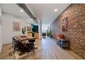 Open-concept living and dining area with exposed brick walls and modern furnishings at 800 Peachtree Ne St # 8429, Atlanta, GA 30308