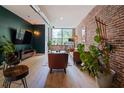 Spacious living room with dark green accent wall and large windows and exposed brick at 800 Peachtree Ne St # 8429, Atlanta, GA 30308