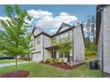 A two-story home with a well-maintained lawn and trees, complimented by stone and siding accents at 1867 Castleberry Ln, Buford, GA 30518
