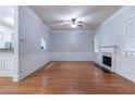Open-concept living room with hardwood floors, fireplace, ceiling fan, and white trim at 204 Saintvry Path, Atlanta, GA 30349