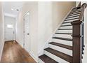 Bright entryway with hardwood floors, staircase with dark wood treads, and a white front door at 213 Starr Cir, Stockbridge, GA 30281