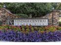 Vinings Central Condominiums sign framed by stone pillars and vibrant purple and pink flowers at 2814 Vinings Central Se Dr # 151, Atlanta, GA 30339