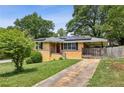 Brick home featuring solar panels, a carport, and a neatly kept front lawn on a sunny day at 3314 Glenco Dr, Decatur, GA 30032