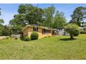 Quaint brick home with a well-maintained lawn and lush, mature trees surrounding the property at 3314 Glenco Dr, Decatur, GA 30032