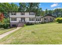 Traditional two-story home with a well-manicured lawn, enhanced by mature trees and a brick facade at 3441 Sherrod Sw Dr, Marietta, GA 30060