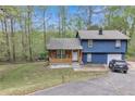 Two-story home featuring an attached garage, a rustic porch and driveway with a neatly manicured front lawn at 3819 Shane Ct, Ellenwood, GA 30294