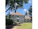 Charming two-story home featuring a well-manicured lawn, gray siding, and classic architectural details at 435 Chantenay Pl, Alpharetta, GA 30022